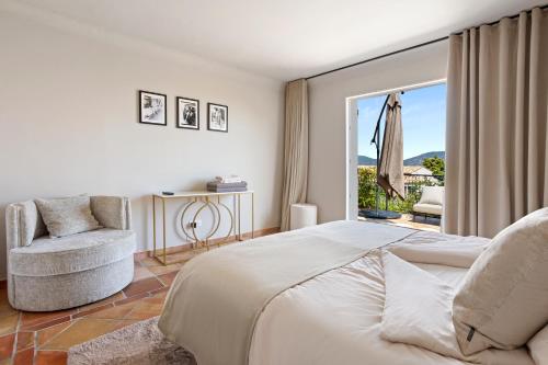 une chambre avec un lit, une chaise et une fenêtre dans l'établissement Villa Bohème, à Saint-Tropez