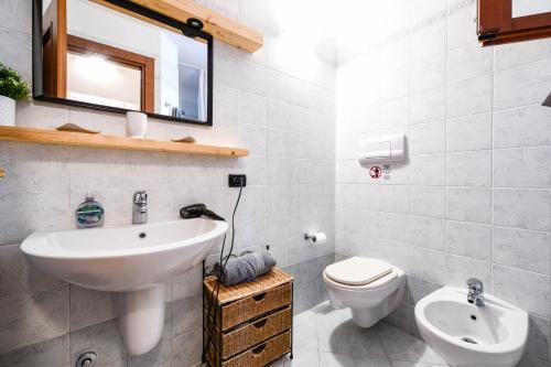 ein Badezimmer mit einem Waschbecken, einem WC und einem Spiegel in der Unterkunft ACE Albatros GHH in Toscolano-Maderno
