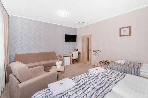 sala de estar con cama y sofá en Hotel Roudna en Plzeň