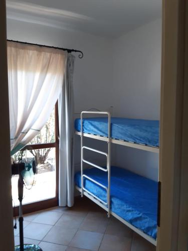a room with two bunk beds next to a window at Mare & Mirice - Case Appartamenti Vacanza in Aglientu