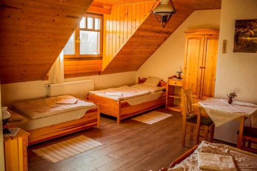 a attic room with two beds and a staircase at Nosztalgia Vendégház in Zalaegerszeg