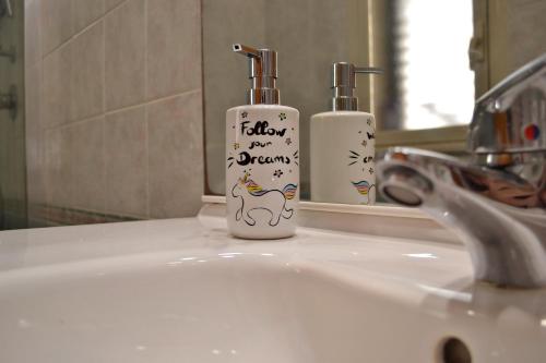 a bathroom sink with two soap bottles on it at Happie Casa Stazione Centrale in Palermo