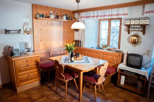 a kitchen with a table and chairs and a tv at Landhaus Geierwally in Elbigenalp