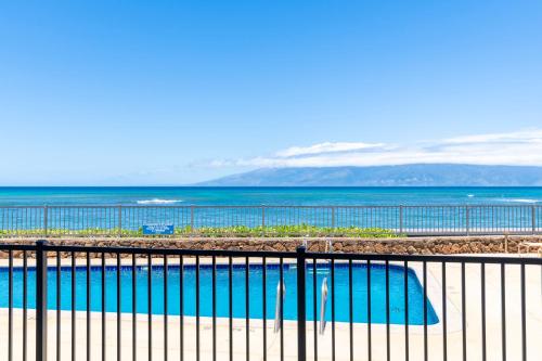 a swimming pool with the ocean in the background at Kahana Reef 106 in Kahana