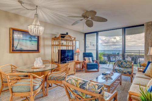 a living room with a couch and a table and chairs at Kahana Reef 106 in Kahana