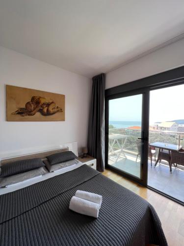 Paradise Apartments Becici في بيشيشي: غرفة نوم مع سرير وإطلالة على المحيط