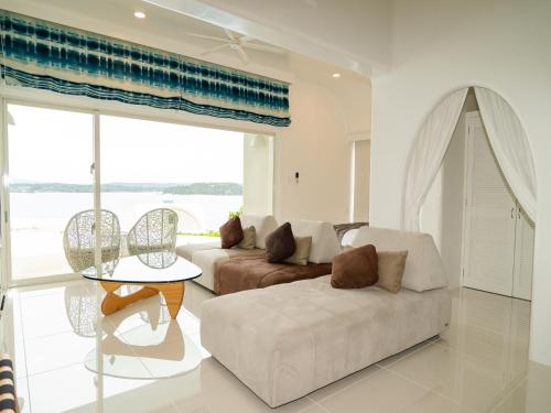 a living room with a couch and a table at Yuki Suite Kourijima in Nakijin
