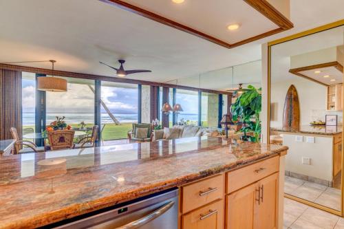 a kitchen with a large counter and a living room at Papakea F105 in Lahaina