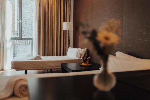 a hotel room with a bed and a couch at Gran Hotel Don Manuel in Cáceres