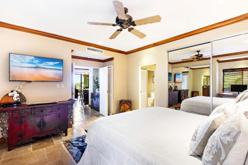 a bedroom with two beds and a ceiling fan at Kapalua Golf Villa 18T 1&2 in Kahana