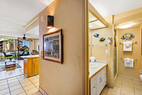 La salle de bains est pourvue d'un lavabo et d'un miroir. dans l'établissement Papakea B204, à Lahaina