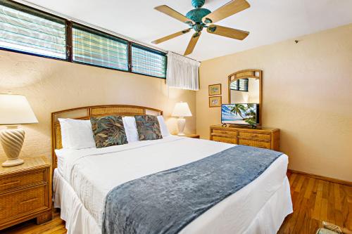 a bedroom with a bed and a ceiling fan at Papakea B204 in Lahaina