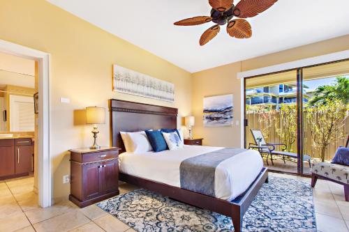 a bedroom with a bed and a ceiling fan at Kapalua Bay Villa 24G2 in Kahana