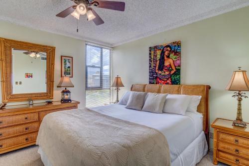 1 dormitorio con cama, espejo y tocador en Maui Kai 801, en Kahana