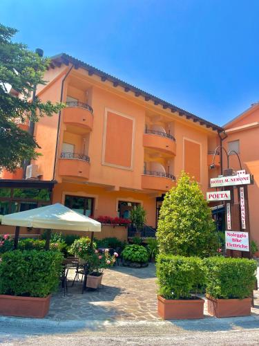 an orange building with an umbrella and a patio at Hotel Ristorante Montenerone Il Poeta in Apecchio