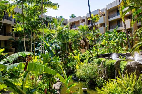 a garden in front of a building with a fountain at Paki Maui 211 in Kahana