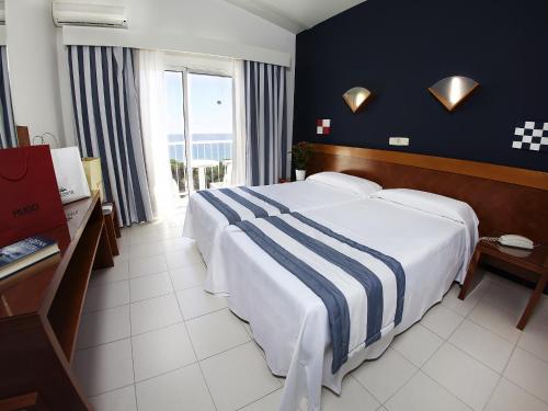 a hotel room with a large bed and a window at Hotel Els Pins in Platja  d'Aro