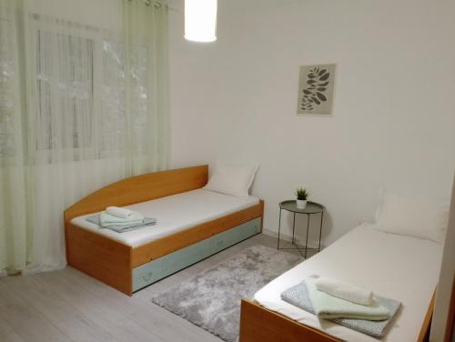 a small bedroom with two beds and a window at Apartment Danilia in Sandanski