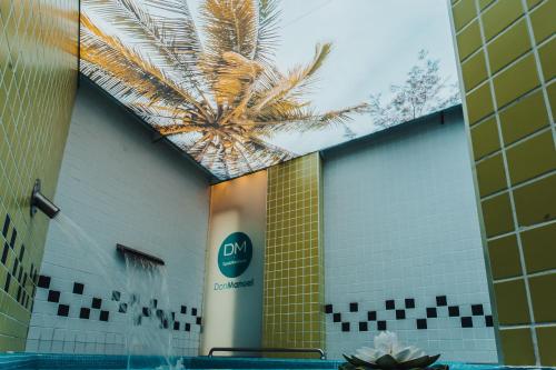 a building with a palm tree on the side of it at Gran Hotel Don Manuel in Cáceres