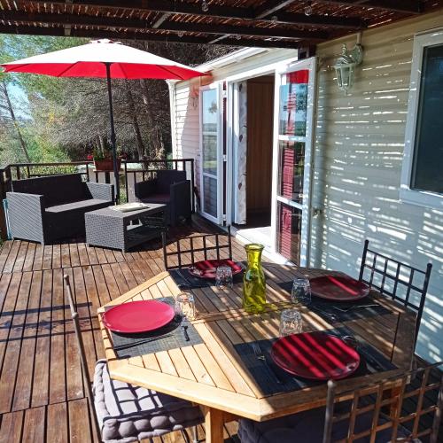 une table et des chaises en bois sur une terrasse avec un parasol dans l'établissement Cottage 