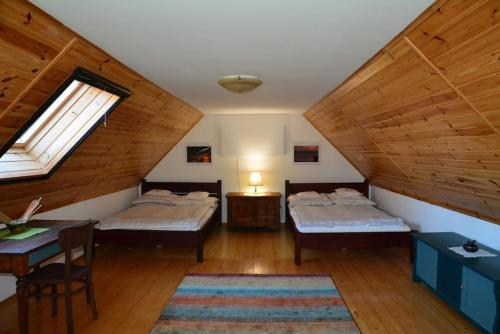 a attic room with two beds and a table at Dom nad jeziorem Granicznym in Stary Żabin