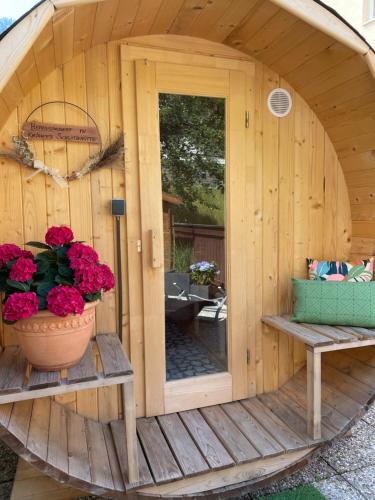 a small wooden sauna with a pot of flowers in it at Loft Krämerhaus Annaberg, Dachstein West in Annaberg im Lammertal