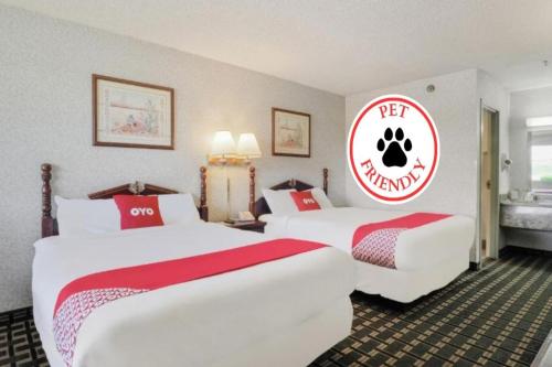 two beds in a hotel room with a red and white sign at Lonestar Inn & Suites, Erick OK Hwy 40 BY OYO in Erick