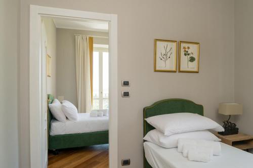 a bedroom with two beds and a mirror at MONFERRATO HILLS Charming Garden Villa in Vignale Monferrato