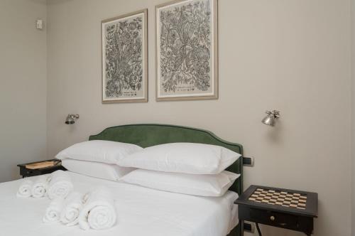 a bed with white pillows and a green head board at MONFERRATO HILLS Charming Garden Villa in Vignale Monferrato