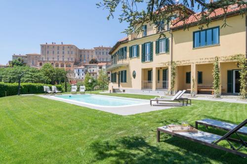 an exterior view of a house with a yard with a swimming pool at MONFERRATO HILLS Charming Garden Villa in Vignale Monferrato