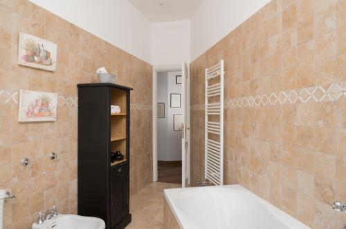 a bathroom with a tub and a toilet and a sink at MONFERRATO HILLS Charming Garden Villa in Vignale Monferrato