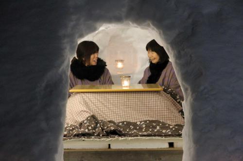 two women standing in a bed in a snow cave at Nakaodaira in Takayama