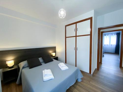 a bedroom with a bed with two towels on it at Apartamento Ara Boltaña in Boltaña