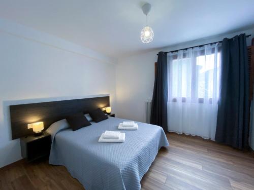 a bedroom with a bed with two towels on it at Apartamento Ara Boltaña in Boltaña