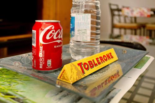 a tray with a can of coke and a bag of toadride at Residencial Sol Suite in Telde