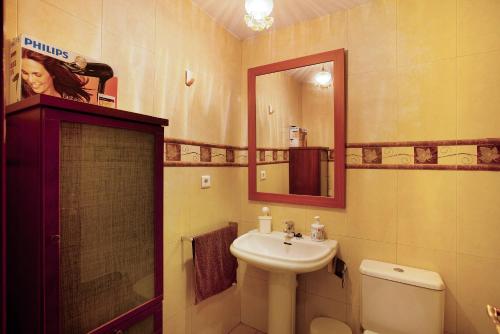 ein Badezimmer mit einem Waschbecken, einem WC und einem Spiegel in der Unterkunft Residencial Sol Suite in Telde