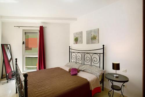 a bedroom with a bed and a table and a window at Residencial Sol Suite in Telde