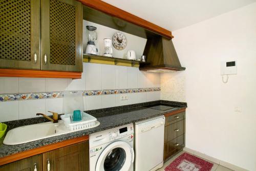 a kitchen with a washing machine and a sink at Residencial Sol Suite in Telde