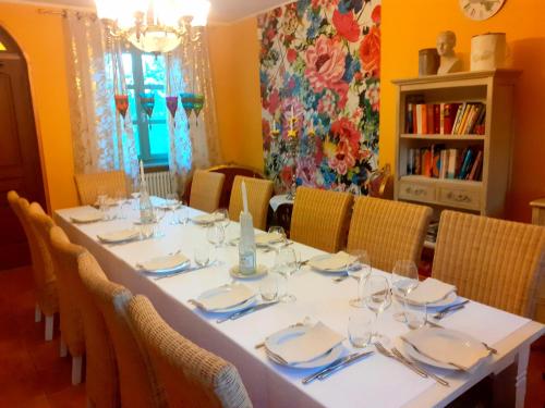 a dining room with a white table and chairs at Villa "Piemonte" in Tigliole