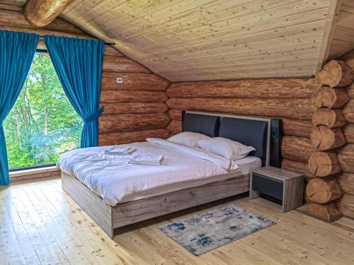 a bedroom with a bed in a log cabin at Cabana Arsita Poienii in Borsa