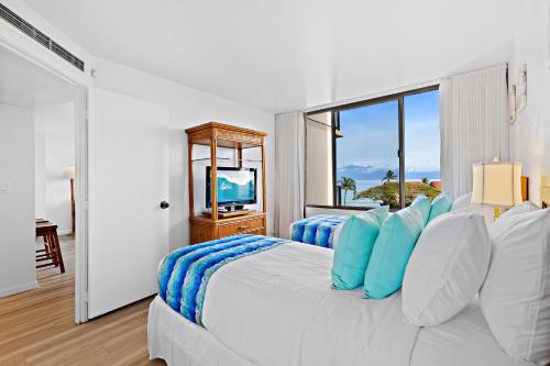 - une chambre blanche avec un grand lit et des oreillers bleus dans l'établissement Kaanapali Shores 616, à Kahana