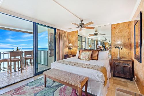 a bedroom with a bed and a balcony at Hololani A402 in Kahana