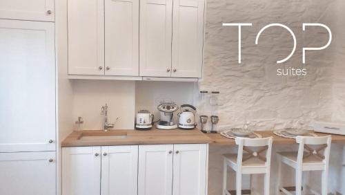 a kitchen with white cabinets and a counter top at TOP SUITES in Ermoupoli