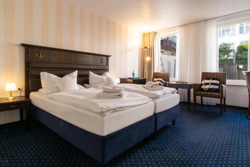 a hotel room with a large bed with white sheets at Promenadenhotel Admiral in Bansin