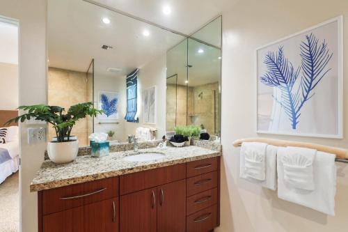 ein Badezimmer mit einem Waschbecken und einem großen Spiegel in der Unterkunft Kapalua Golf Villa 21V 1 in Kahana