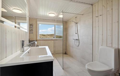 La salle de bains est pourvue de toilettes, d'un lavabo et d'une douche. dans l'établissement Gorgeous Home In Hvide Sande With Sauna, à Havrvig