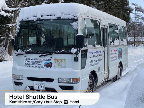 a bus covered in snow on a snowy road at Hakuba Park Hotel in Hakuba