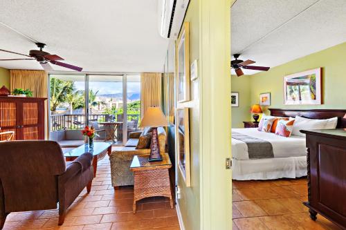 a bedroom with a bed and a living room at Nani Kai Hale 404 in Kihei
