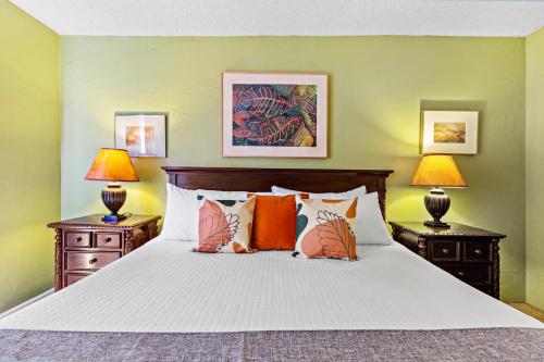 a bedroom with a large white bed with two lamps at Nani Kai Hale 404 in Kihei