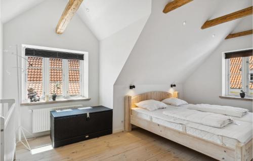 a white bedroom with a bed and two windows at Stunning Home In Skagen With 3 Bedrooms And Wifi in Skagen